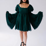 Dark emerald green mini dress with dramatic bell sleeves and lace trim.