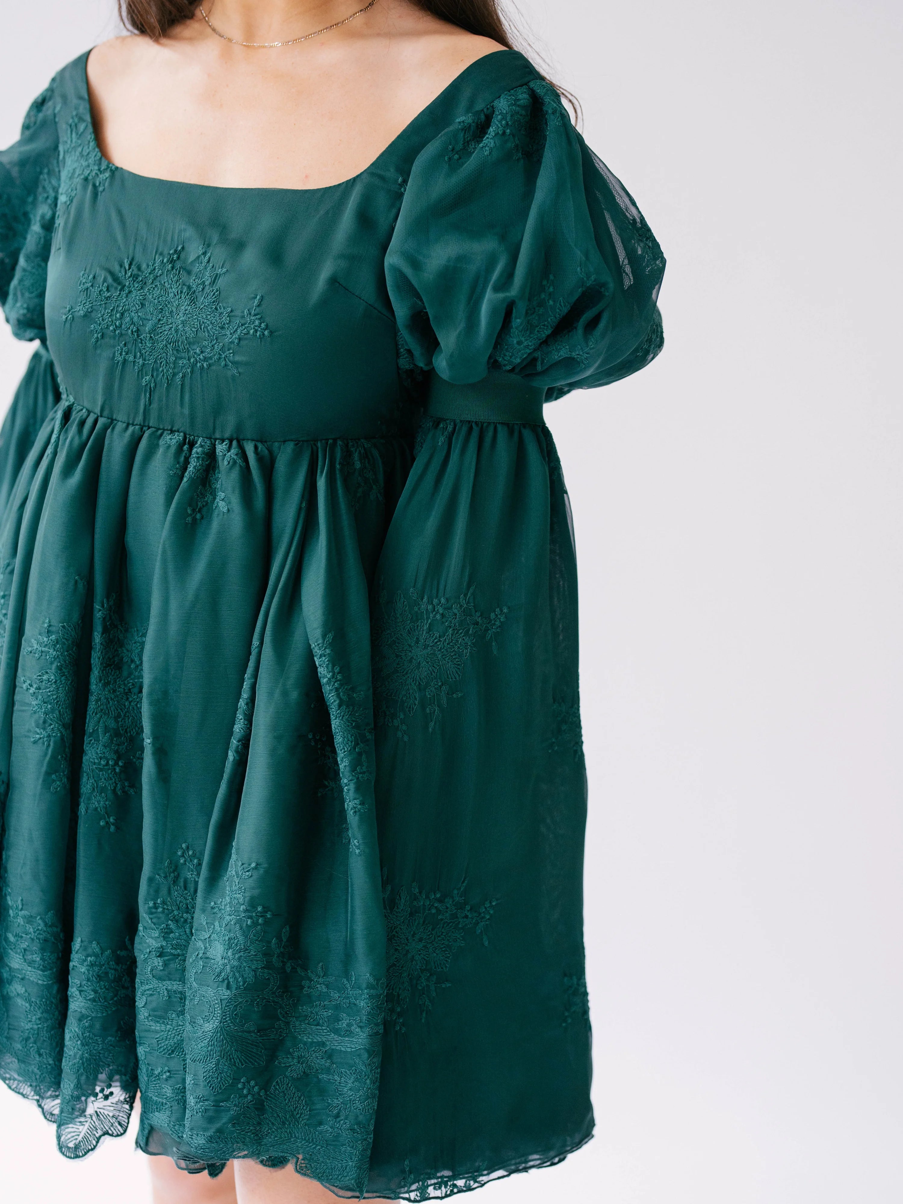 Forest green holiday mini dress with puff sleeves and embroidered details.