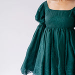 Emerald green holiday mini dress with puffy bell sleeves and embroidered details.