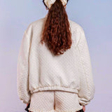 Person with long brown hair in a white sweater and shorts showcases Adella Jacquard Bomber