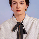 Young woman in white blouse and black bow tie with Adella Jacquard Bomber Jacket