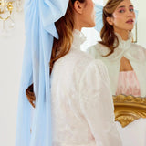 Woman in a white top showcasing The Alice Blue Giant Flutter Bow hairstyle accessory