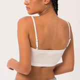 Woman in white crop top showcasing The Atwood Camisole with a grand bow sash