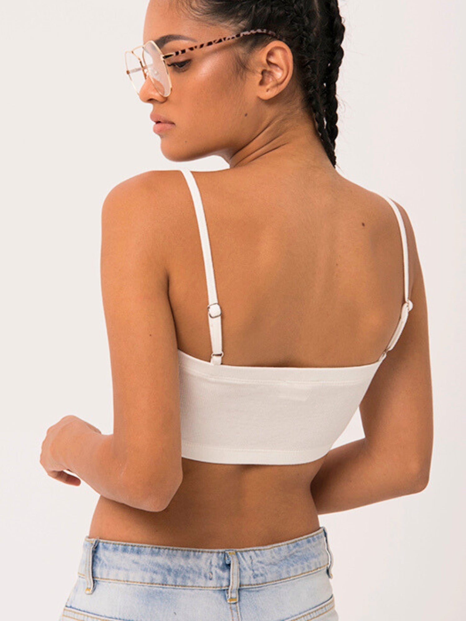 Woman in white crop top showcasing The Atwood Camisole with a grand bow sash