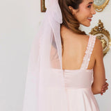 Smiling bride wearing a white wedding dress with a Giant Flutter Bow in her hair