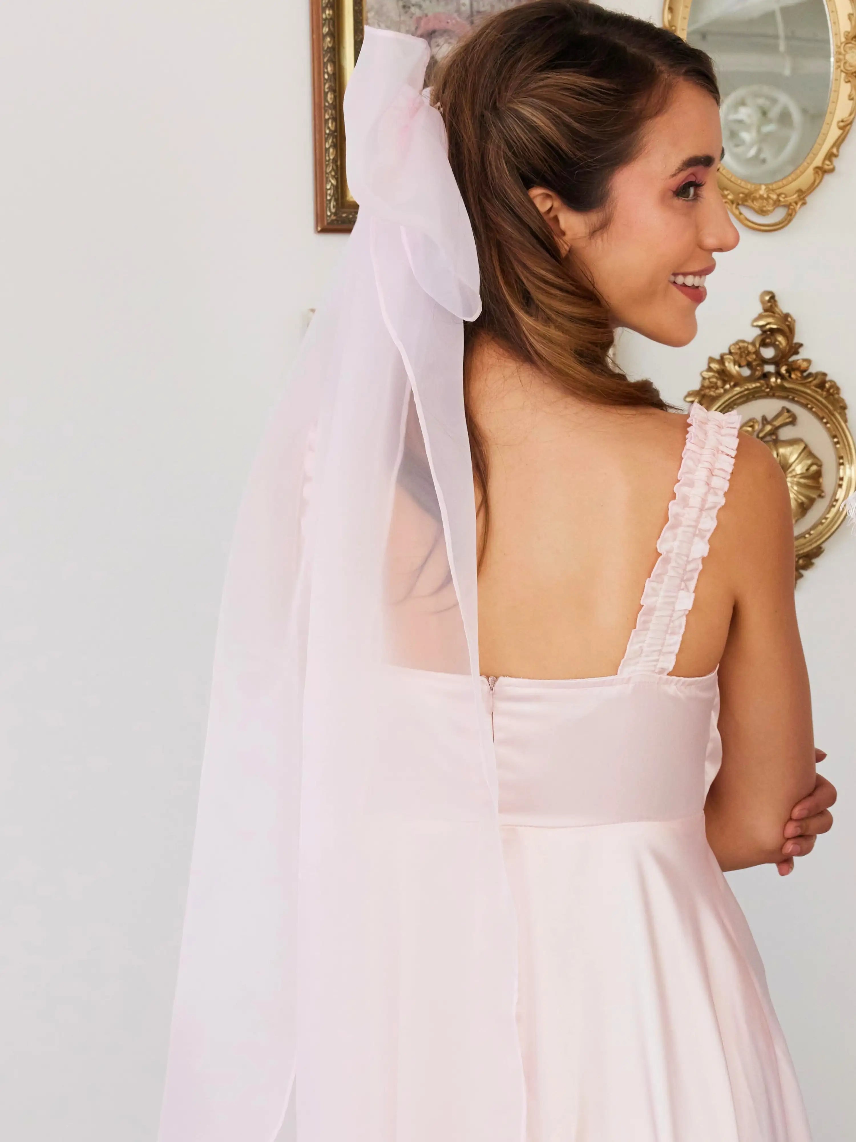 Smiling bride wearing a white wedding dress with a Giant Flutter Bow in her hair