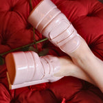 Top view of Barbie’s Pink Penny Loafers worn on feet, highlighting the penny strap detail and thick platform heel on a red velvet background.