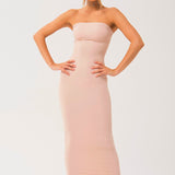 Woman in a strapless long cami slip dress, showcasing a form-fitting pale pink design