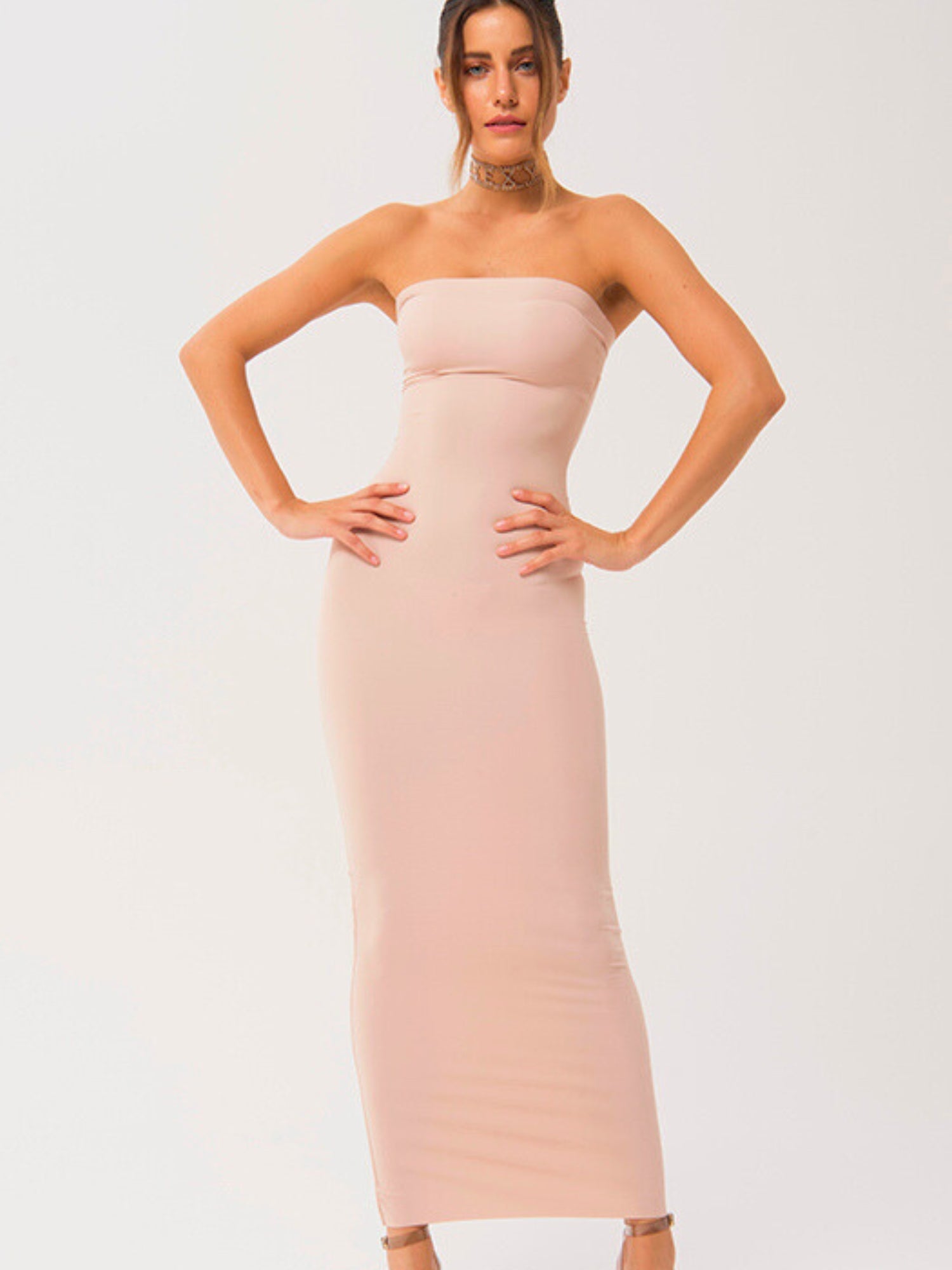 Woman in a strapless long cami slip dress, showcasing a form-fitting pale pink design