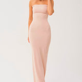 Woman in a strapless long cami slip dress, featuring a pale pink form-fitting design