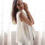 Woman modeling The Beaded Botanic Top by Sister Jane, hands near her face