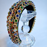 Ornate jewel-encrusted crown headband displayed elegantly on a clear stand