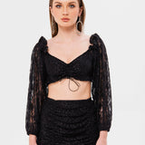 Woman modeling the Black Magic Lace Crop Top with a matching skirt and long sleeves