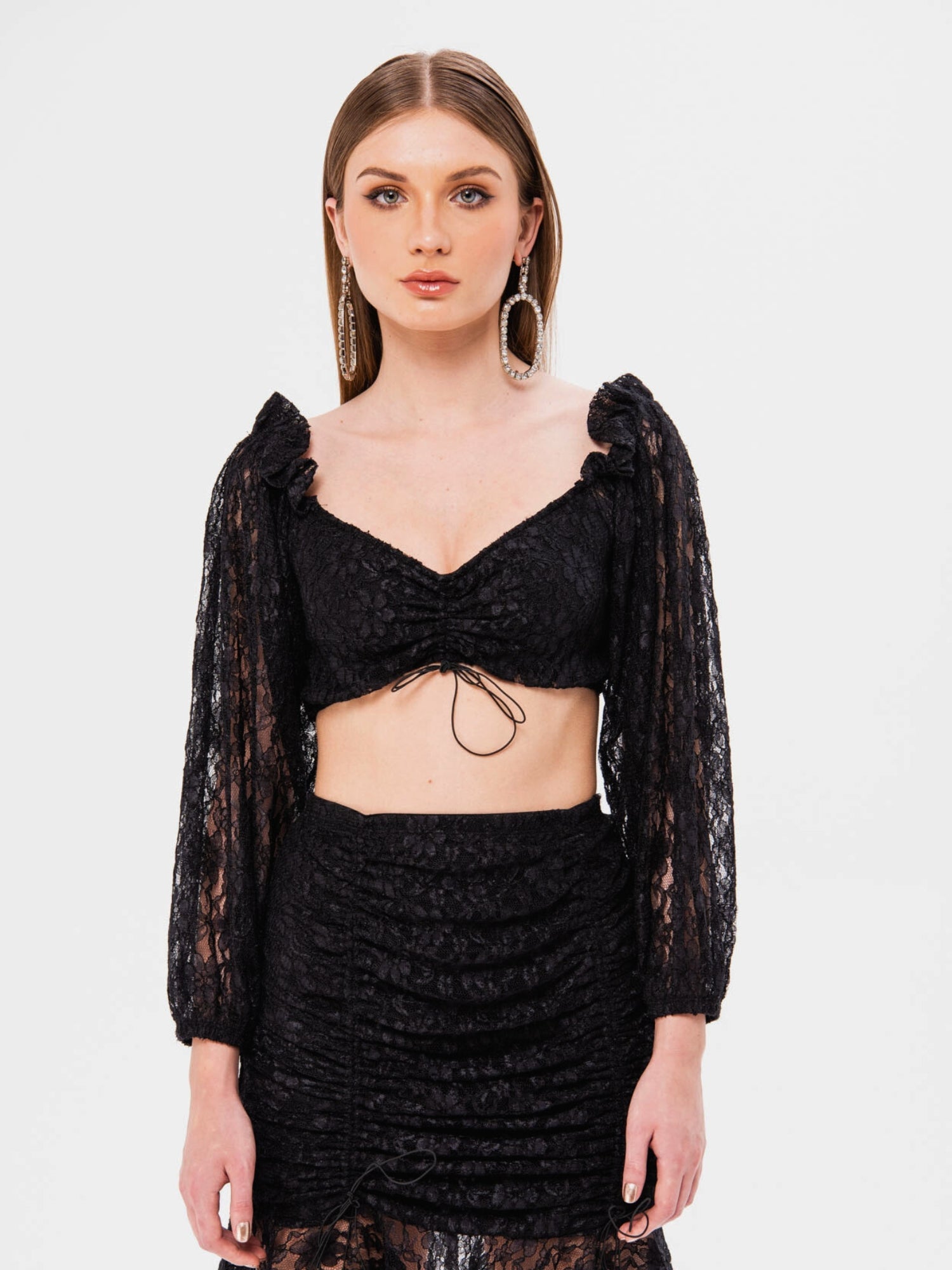 Woman modeling the Black Magic Lace Crop Top with a matching skirt and long sleeves