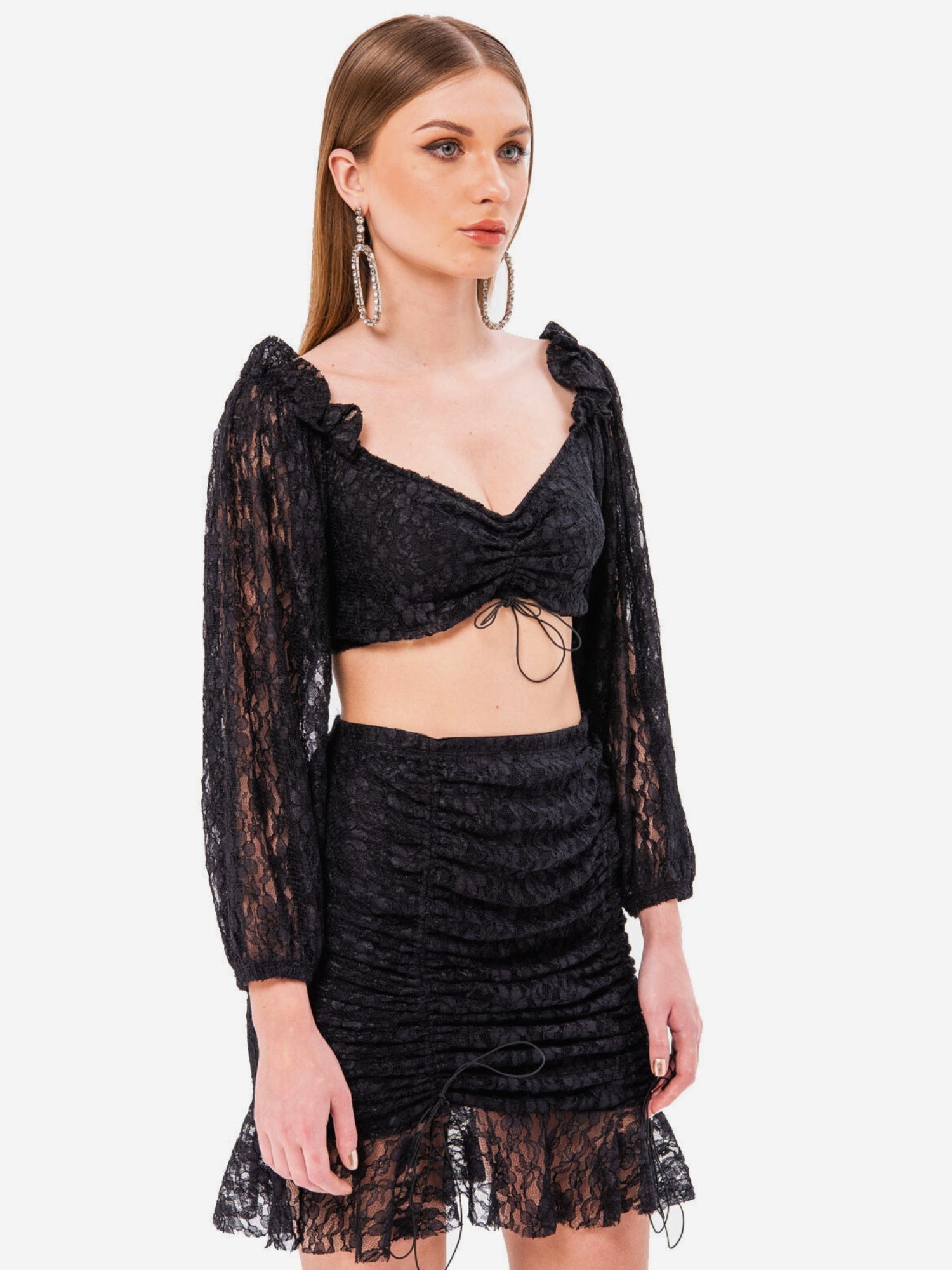 Woman in a black magic lace crop top and mini skirt showcasing elegance and style