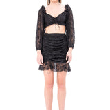 Woman in black magic lace crop top with puffed sleeves and elegant lace details