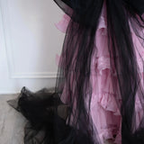 Close-up of The Black Swan Grand Bow Sash's flowing black tulle tails cascading over a pink tiered lace skirt.