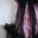 Close-up of The Black Swan Grand Bow Belt's flowing black tulle tails cascading over a pink tiered lace skirt, showcasing its dramatic design.