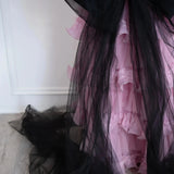 Close-up of The Black Swan Grand Bow Belt's flowing black tulle tails cascading over a pink tiered lace skirt, showcasing its dramatic design.