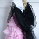 Side view of The Black Swan Grand Bow Belt highlighting its structured black satin bow and sheer tulle layers over a pink lace-tiered skirt.