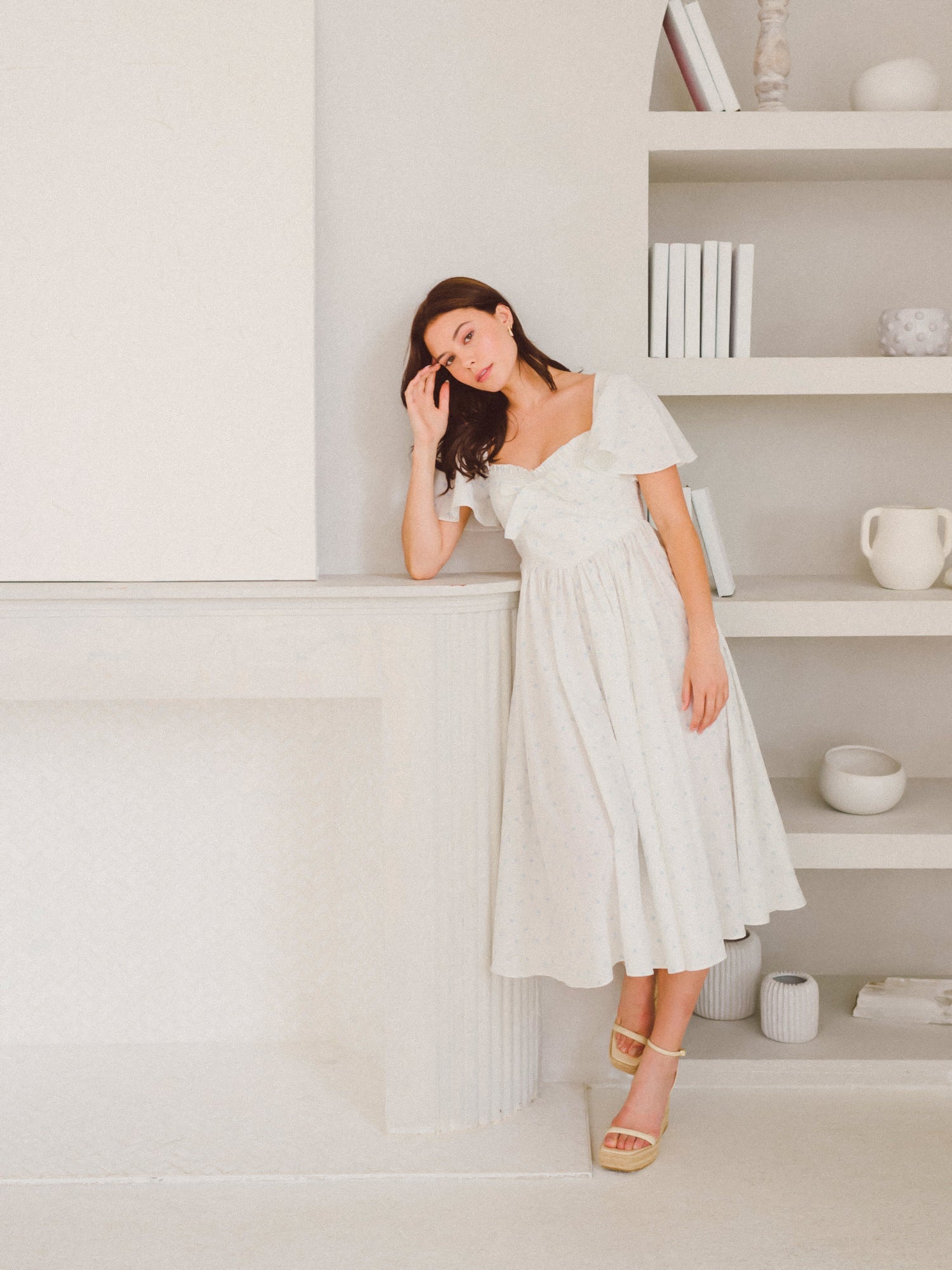 Woman in a white off-shoulder dress, showcasing the Blue Blooms French Milkmaid Dress