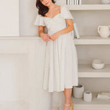 Woman in white off-shoulder midi dress from Blue Blooms French Milkmaid collection