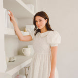 Woman in a white puffed sleeve dress featuring the Blue Blooms Lamb Mini Dress design