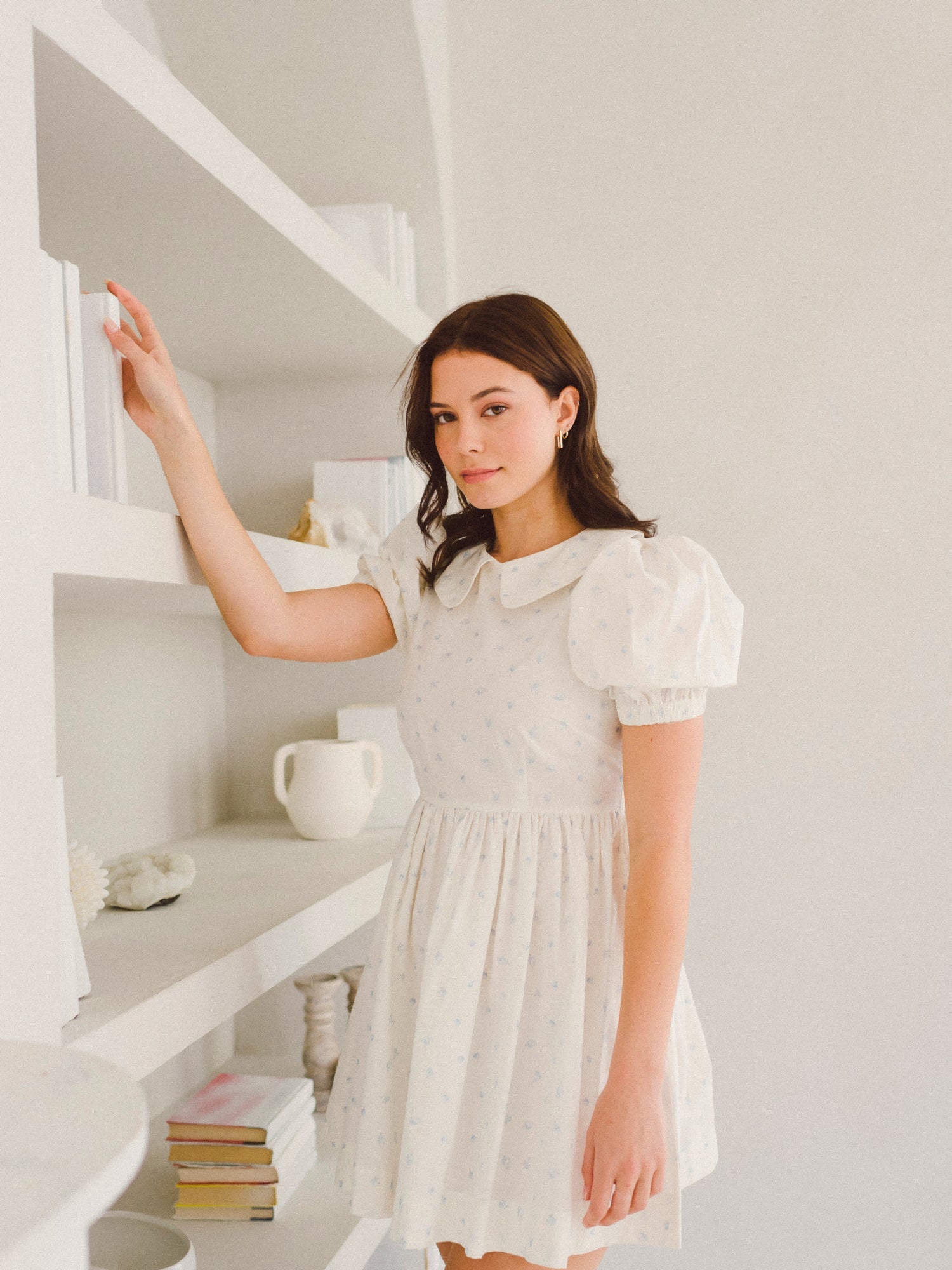 Woman in a white puffed sleeve dress featuring the Blue Blooms Lamb Mini Dress design