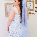 Woman in a flowing blue toile gown with a long train, showcasing blue toile print elegance