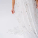 Detail of the Celestial Veil Dauphine Lace Gown's embroidered stars and moons on sheer tulle. Perfect for fantasy-inspired or bridal fashion.