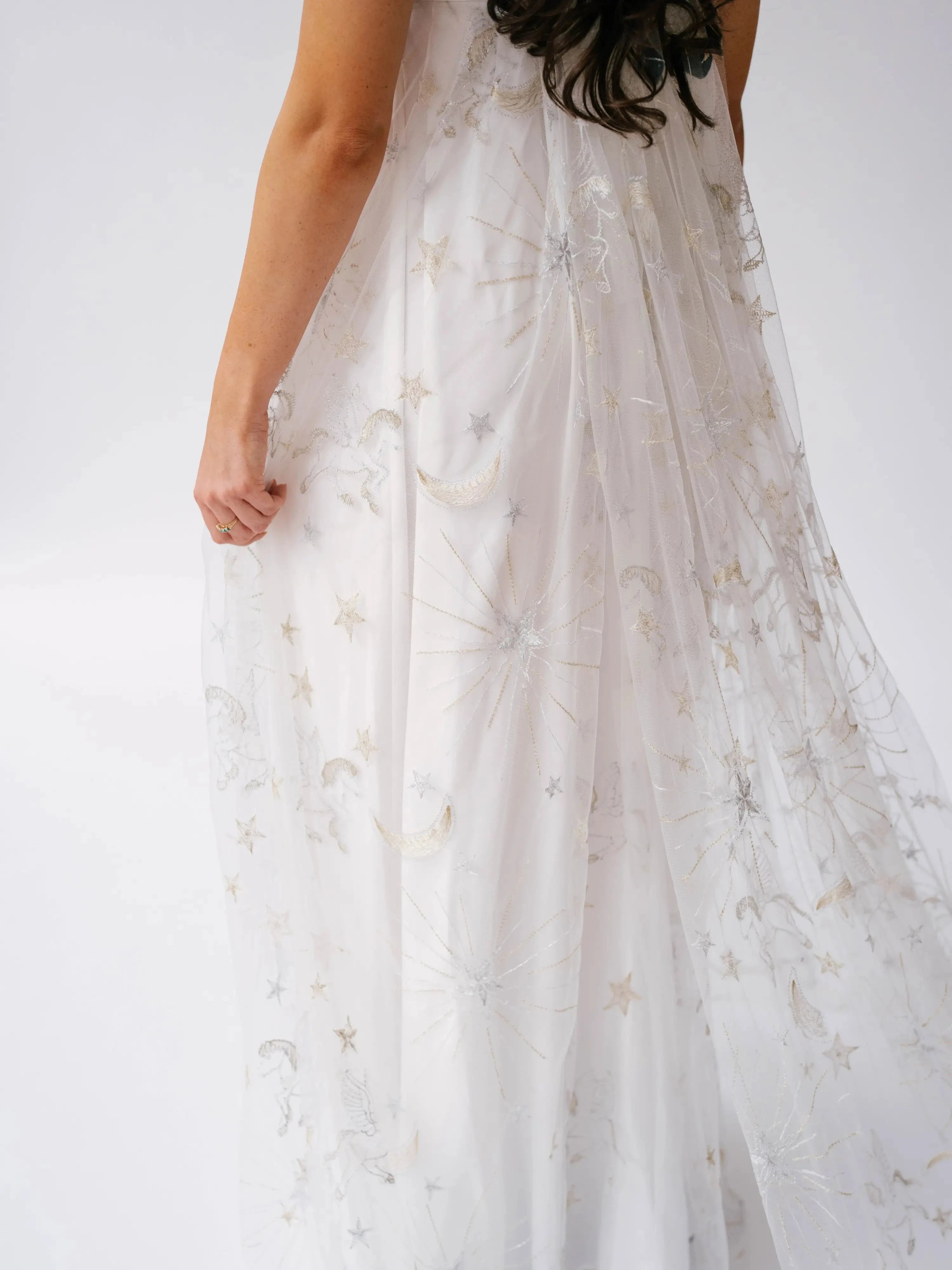 Close-up of the Celestial Veil Dauphine Lace Gown's moon and star embroidery on it's train.