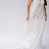 Flowing lace gown with short sleeves and a delicate, ethereal quality.