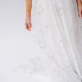 White fabric with delicate gray moon and star patterns on a lace gown.