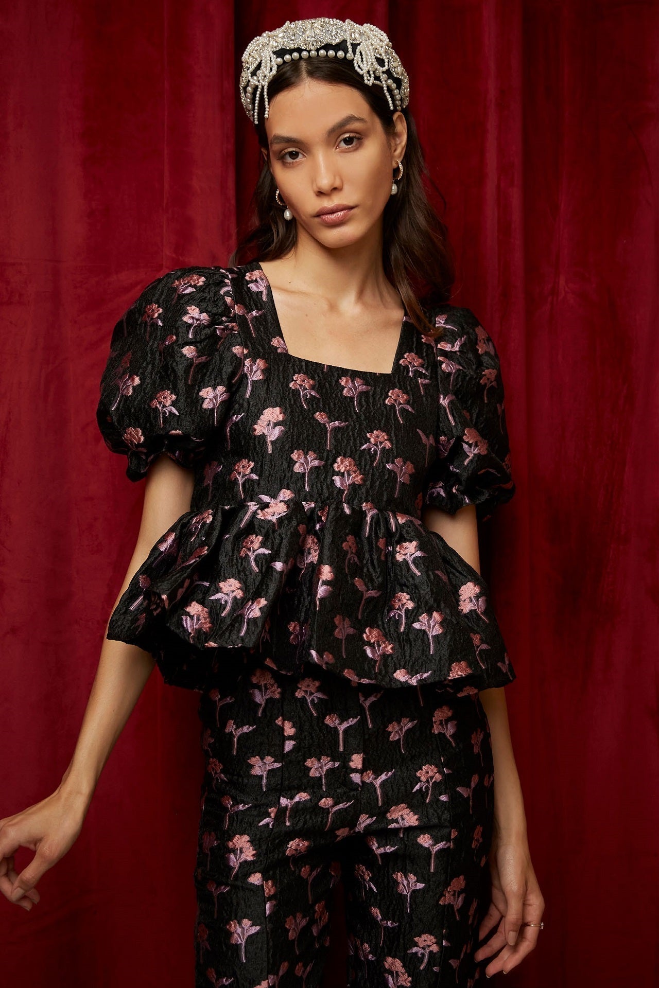 Woman in a Chasse Floral Tie Back Top with black floral puff sleeves and matching pants