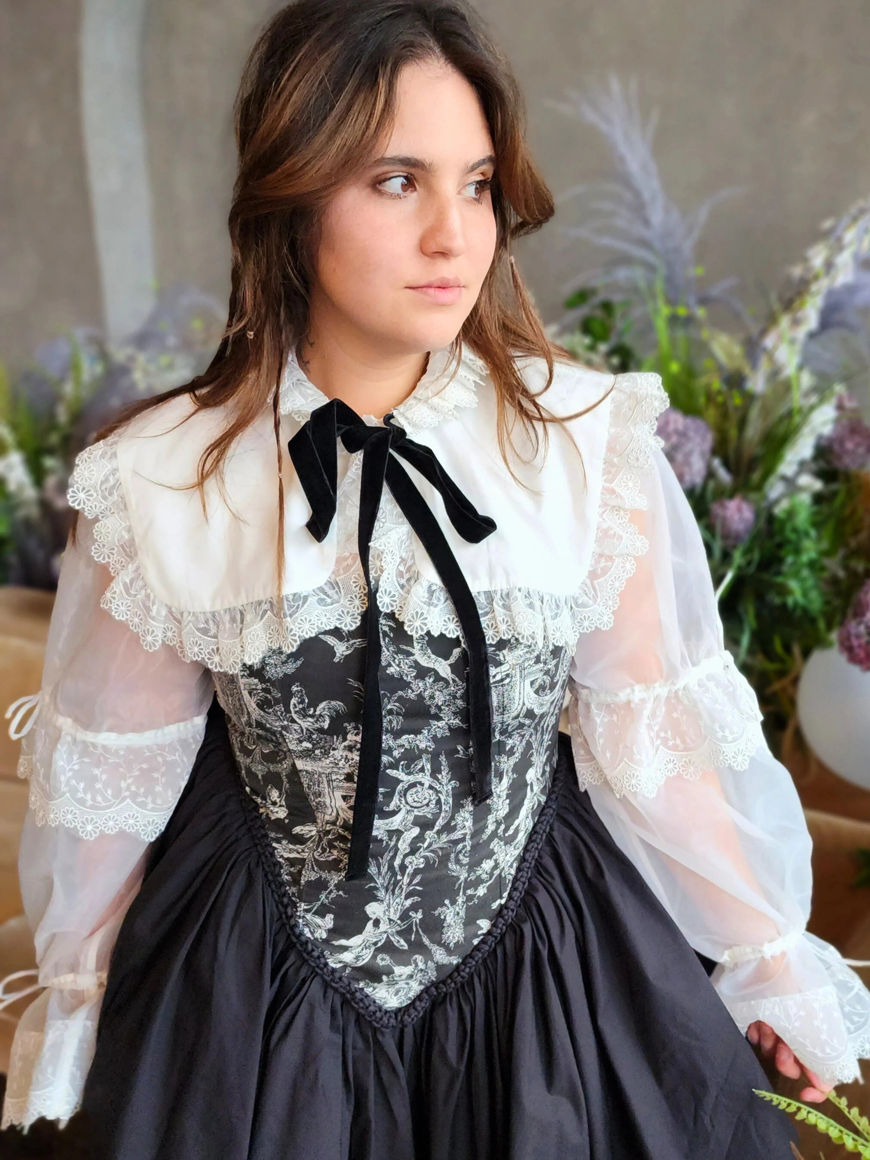 Front view of a woman wearing a Victorian-style corset dress underneath the Ciela Snow White Shrug.