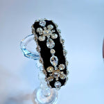 Black diamond goddess headband displayed on a crystal stand.