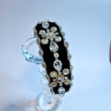 Black diamond goddess headband displayed on a crystal stand.