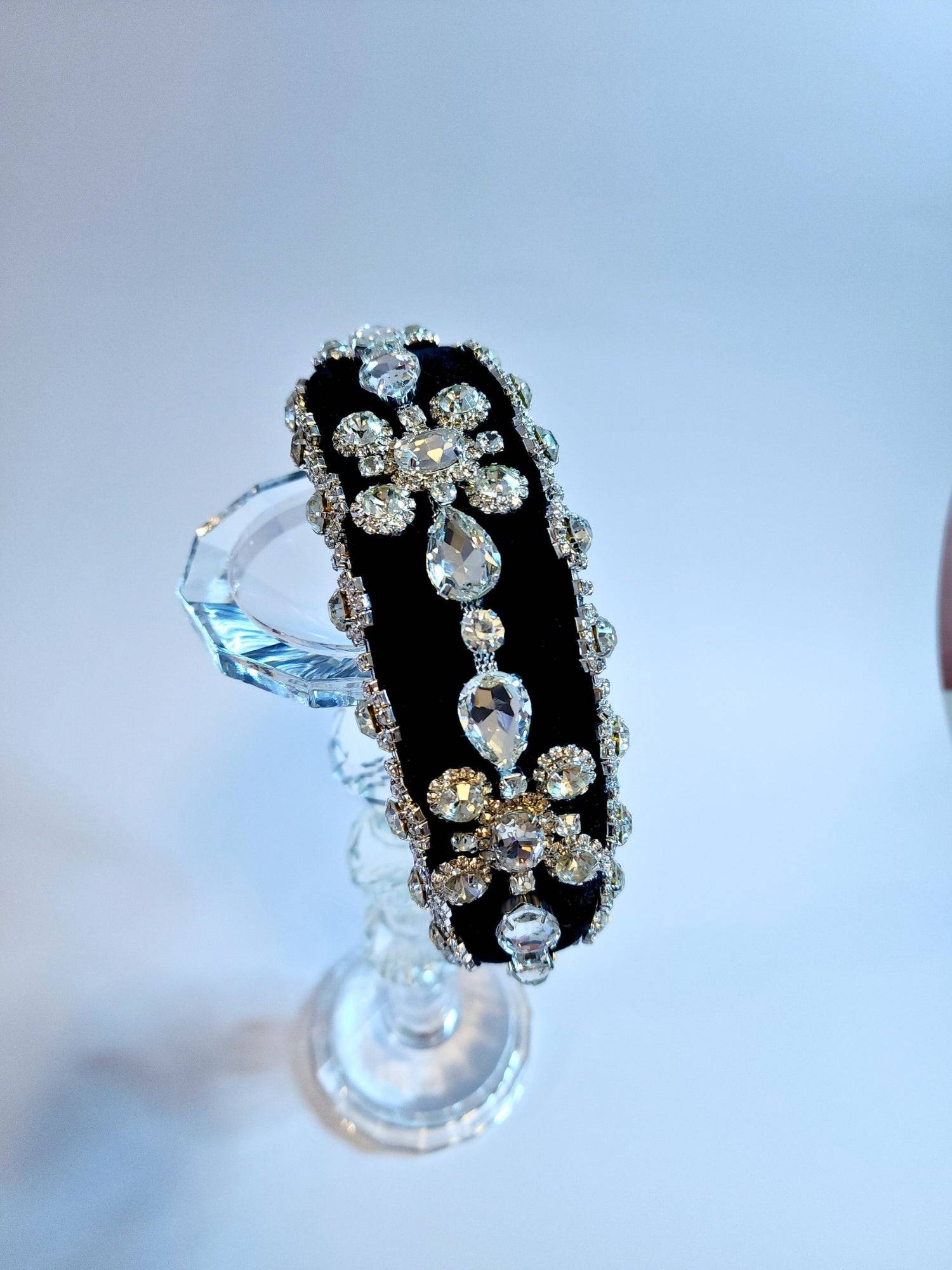 Black diamond goddess headband displayed on a crystal stand.