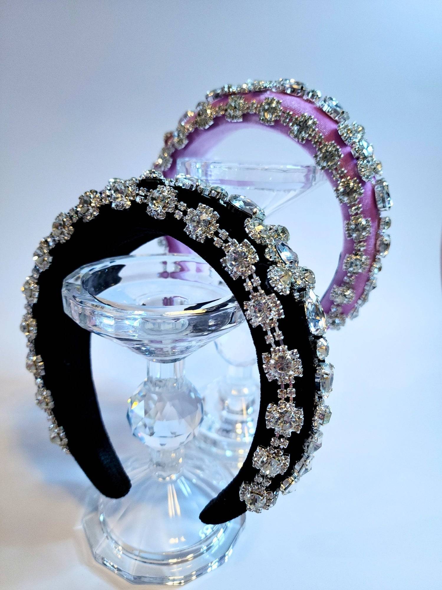 Ornate Diamond Goddess Headbands in black and pink with crystals on a glass stand.