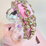 Pink diamond goddess headband displayed on a crystal stand.