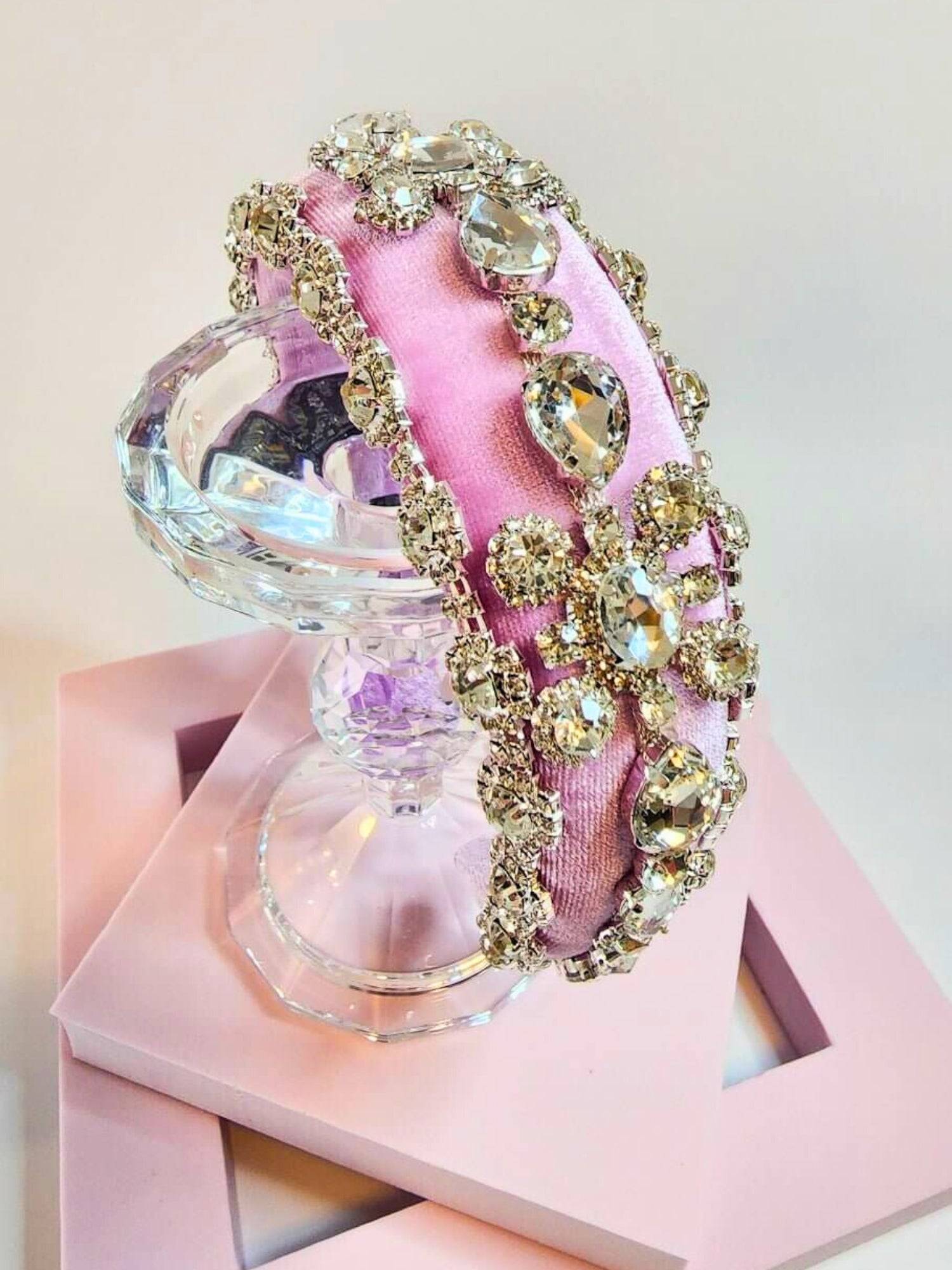 Pink diamond goddess headband displayed on a crystal stand.