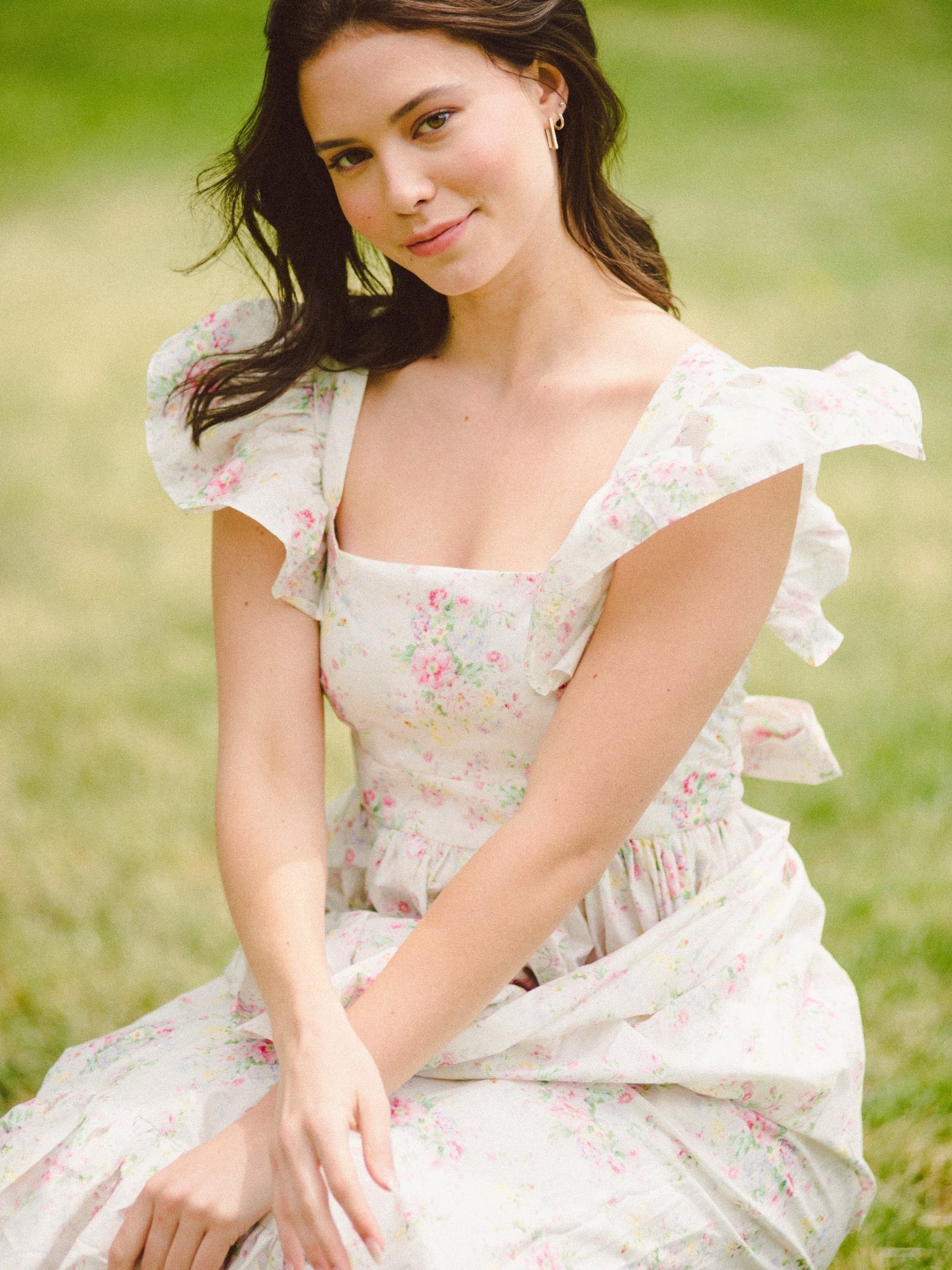 Woman in a white floral dress outdoors, showcasing the Dream Rainbow Apron Maxi