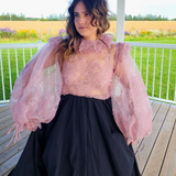 Woman in pink puff dress with voluminous sleeves and black skirt from The Eleanor Top