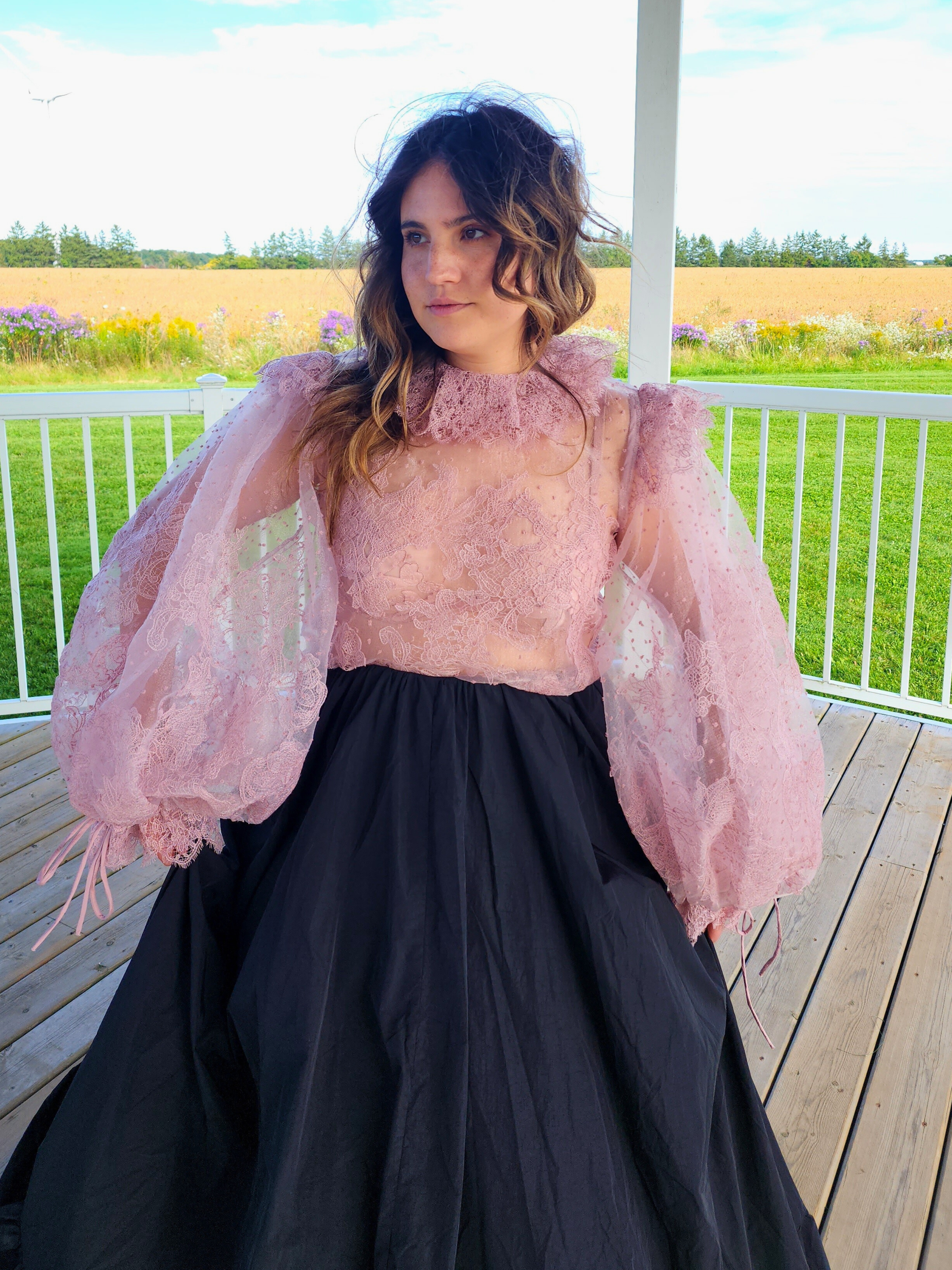 Woman in pink puff dress with voluminous sleeves and black skirt from The Eleanor Top