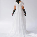 Back view of a person wearing the dauphine lace gown with black lace opera gloves and a black hat against a white background