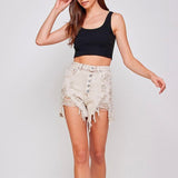 Woman in a black crop top with distressed Facing Trouble denim shorts featuring high waist button