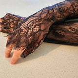 Delicate black lace glove on a hand, perfect with a gown or puff dress