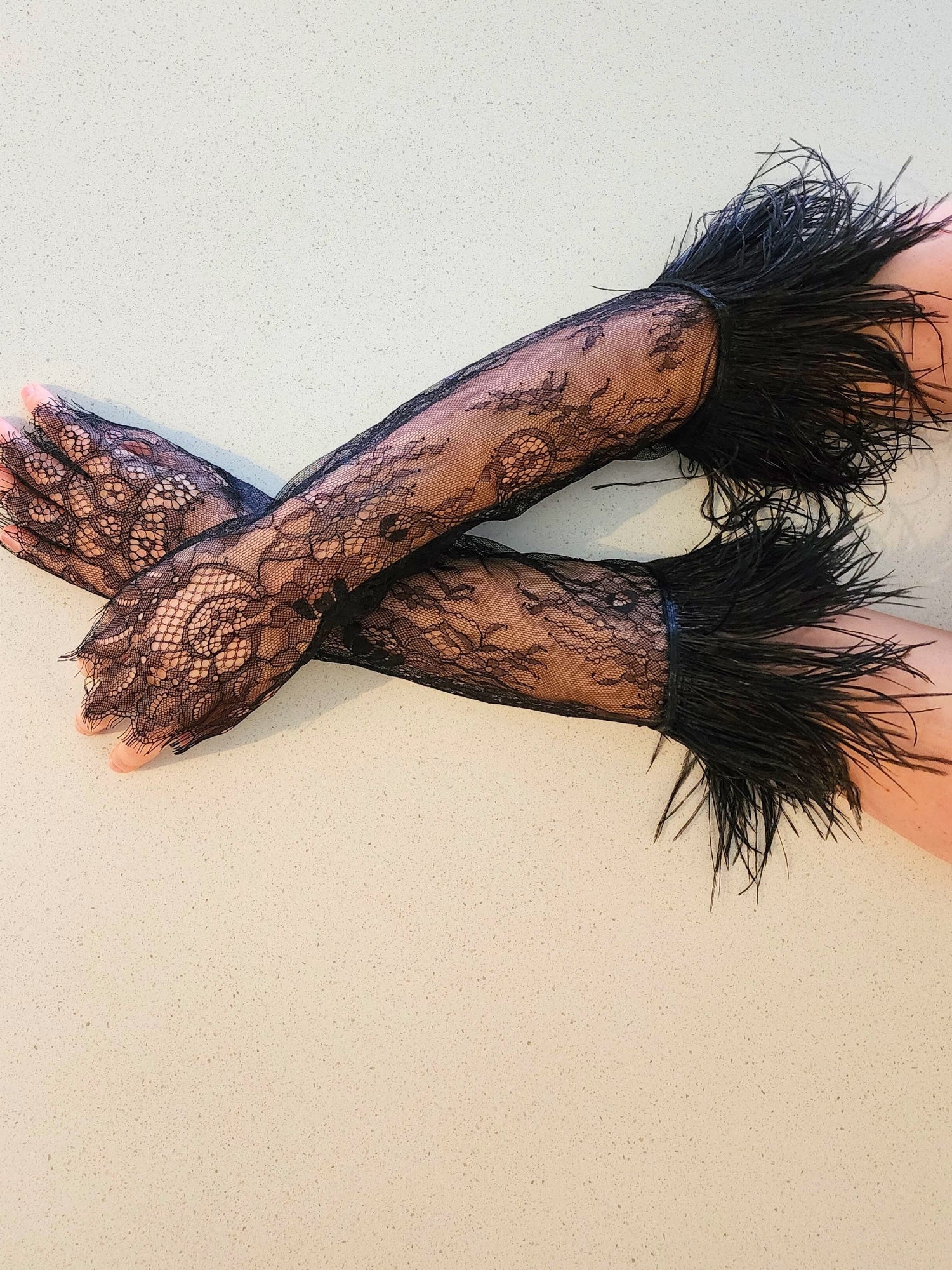 Elegant black lace gloves with feathered cuffs, perfect for pairing with a gown or puff dress