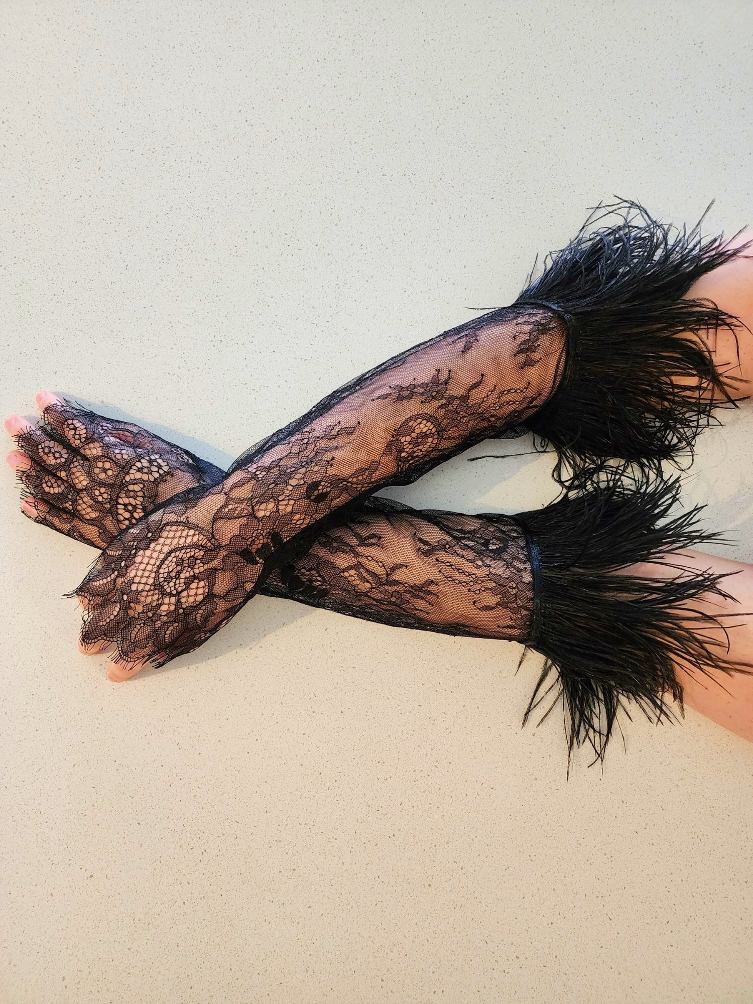 Elegant black lace gloves with feathered cuffs, perfect for a gown or puff dress