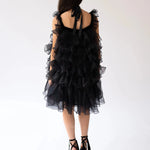 Back view of a woman wearing the light as a feather puff dress in black platform heels.